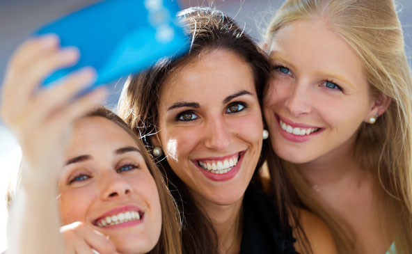 Drei junge Freundinnen beim Schießen eines Selfie mittels Handy
